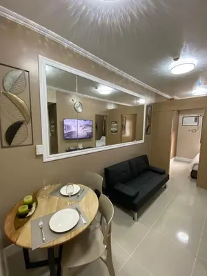 a living room with a table and a couch at 2 BR Fully Furnished Condo in Parañaque with Pool and Parking - Bloom Unit 1134 in Manila