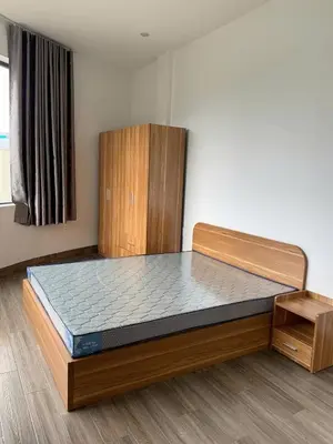 a bed in a room with a wooden bed frame at Magallanes Escape in Manila