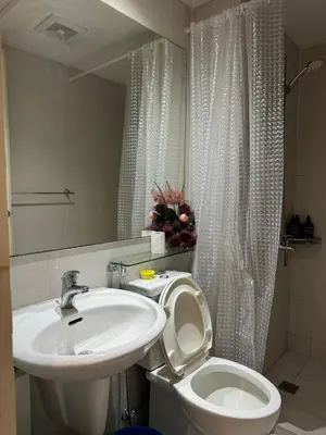 a bathroom with a sink and a toilet and a mirror at Upside Down in Manila