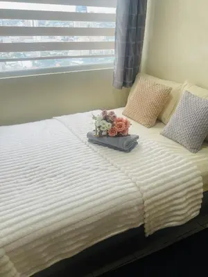 a bed with a tray of flowers on top of it at Haven Suites by Amf in Manila