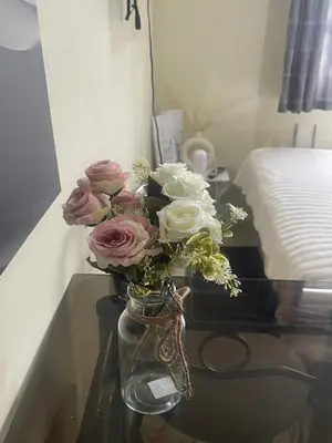a vase filled with pink and white flowers on a table at Haven Suites by Amf in Manila