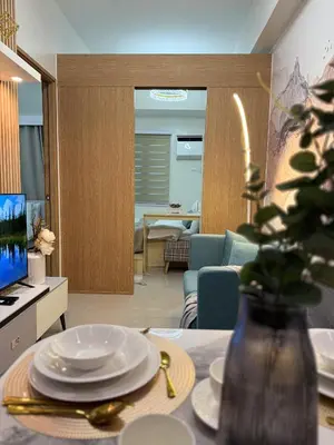 a living room with a table with plates on it at Bright Unit at Bloom near NAIA l WiFi Netflix BLOOM B02-0803 in Manila