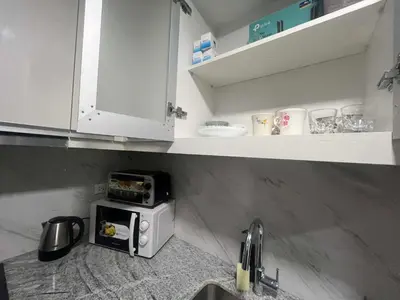 a kitchen with a microwave on top of a counter at Cozy Gentry Manor TV Netflix Seaview near Okada MOA17V in Manila