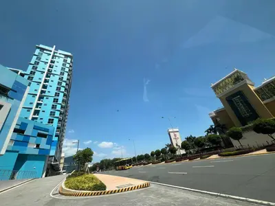 an empty street in a city with a tall building at Cozy Gentry Manor TV Netflix Seaview near Okada MOA17V in Manila