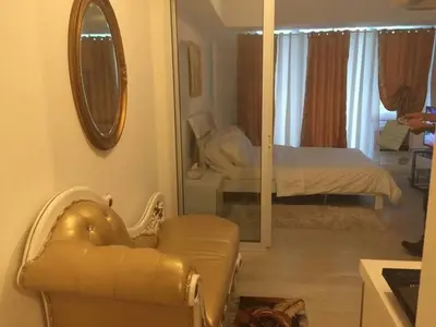 a living room with an elephant chair and a mirror at Azure Resort Condo with Man-Made Beach Pool in Manila