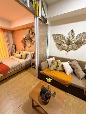 a bedroom with a bed and a couch in a room at Panatag Staycation by Yani at Azure Urban Residences, Parañaque in Manila