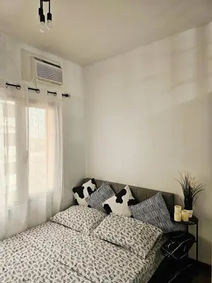a bedroom with a bed with pillows and a window at Paseo Verde Las Pinas - Sleeps 2 Adults 2 Children in Manila