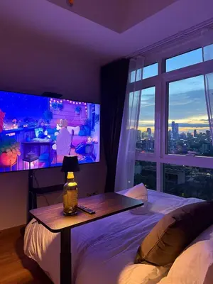 a bedroom with a bed and a large screen television at One uptown Residence,BGC, Manila 1bedroom in Manila