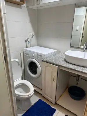 a bathroom with a washing machine and a sink at Sea Residences Elegant Place by Paul in Manila