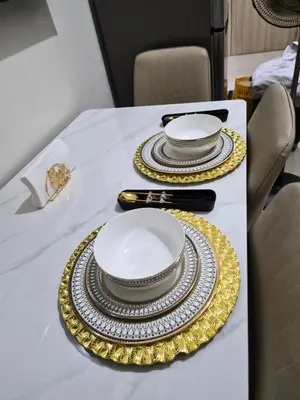 a table with two plates and gold chargers on it at ZEN 2 SHORE RESIDENCES Tower A in Manila