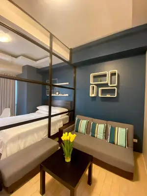 a bedroom with a bed and a couch and a table at Place to stay in Pasay in Manila