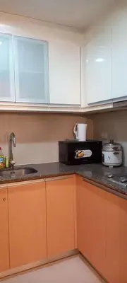 a kitchen with white cabinets and a black counter top at Place to stay in Pasay in Manila