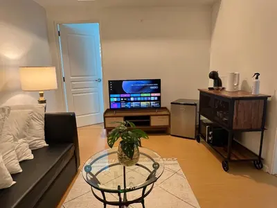 a living room with a couch and a table and a tv at Charming 1-BR in BGC in Manila