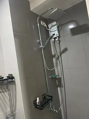 a shower in a bathroom with a shower head at AIR RESIDENCES MAKATI Staycation in Manila