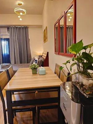 a living room with a table and a dining room at Holland Park staycation in Jalang
