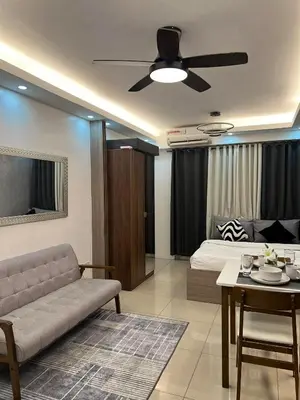a living room with a couch and a ceiling fan at DMV Trinity Stay in Manila