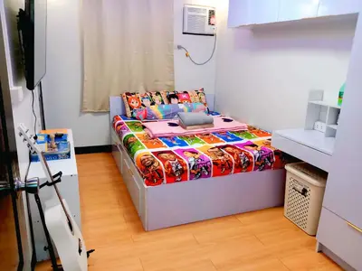 a bedroom with a bed with a colorful comforter at Gabrielle Staycation in Imus