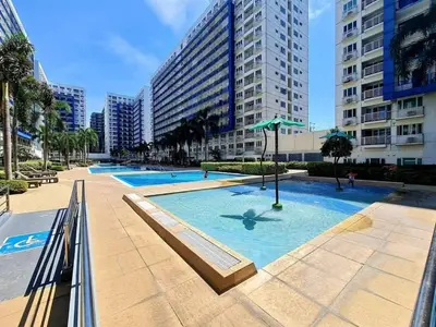 a large swimming pool in a city with tall buildings at Staycation in Pasay in Manila