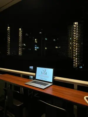 a laptop computer sitting on top of a wooden table at Azure Luxury Condo in Manila