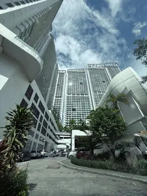 a large building with cars parked in front of it at Modern Condo in Makati with Stylish City Escape in Manila