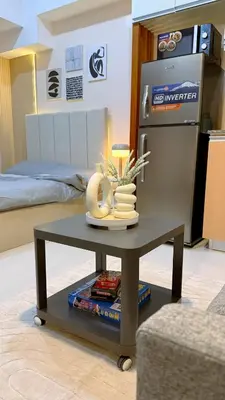 a coffee table in a living room with a refrigerator at A Studio Unit in McKinley Near Venice Grand Canal Mall in Manila
