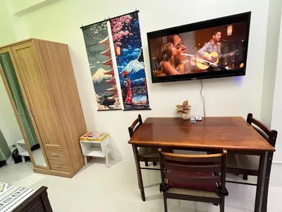 a dining room with a table and a tv on the wall at Near Vista Mall Taguig BGC with Overlooking Veranda Netflix and Pay Parking in Manila