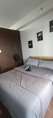 a bedroom with a bed with a laptop on it at Hailar Property Management in Manila