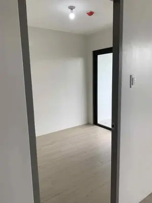 an empty room with a door and a wooden floor at Cozy oozy apartment in Manila