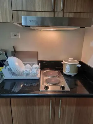 a kitchen counter with a stove and a pot and pans at D'Annes Holistay in Manila