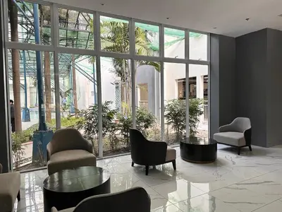 a lobby with chairs and tables and large windows at Casa Doña at Kasara Urban Resort Residences in Manila