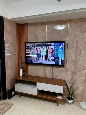 a living room with a flat screen tv on a wall at Casa Doña at Kasara Urban Resort Residences in Manila