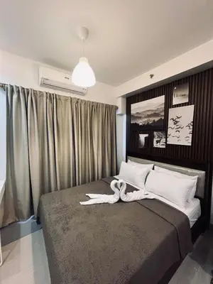 a bedroom with a bed with a swan on it at The Baylight Escape at Shore 2 in Manila