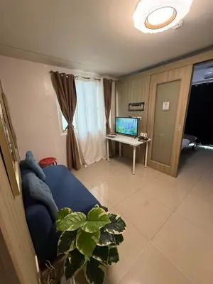 a living room with a couch and a desk with a computer at City Elite Retreats at Shore in Manila