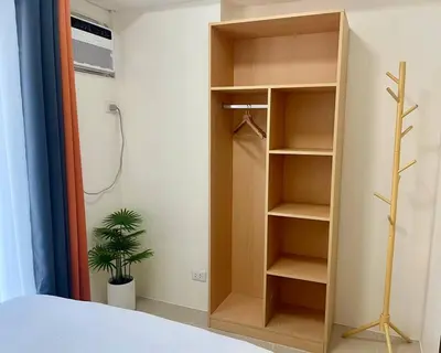 a bedroom with a closet with a shower and a plant at Mandarin Suite Stay in Manila