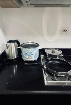 a stove top with two pans and a pot on it at The Tropical Haven at Shore in Manila