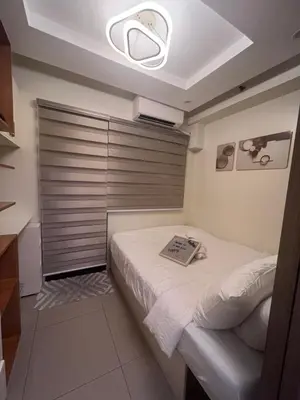 a bedroom with a bed with a book on it at Le Trevi Suite at MOA Pasay Staycation in Manila