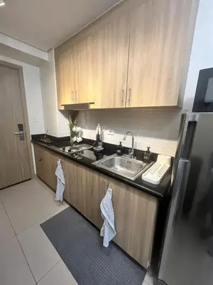 a kitchen with a sink and wooden cabinets at Le Trevi Suite at MOA Pasay Staycation in Manila