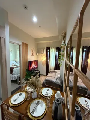 a room with a dining table and a bedroom at Luxe staycation by Joy at Charm Residence Cainta in Manila
