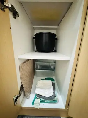 a cabinet with a pot on a shelf with towels at Affordable Airport Staycation SMDC Field Residence in Manila