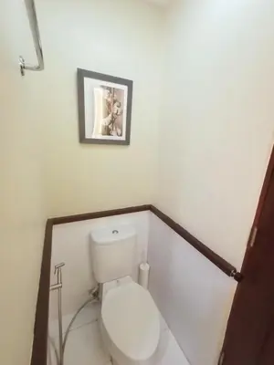 a bathroom with a toilet with a picture on the wall at Casa Rosie in Seibu Tower - homey 1BR near BGC High Street in Manila
