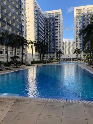a large swimming pool in a city with tall buildings at NEAR SMX, MOA Sea Residence Condotel in Manila