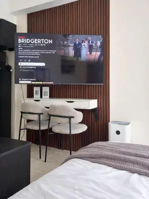 a bedroom with a bed and a table and two chairs at Maison Inea in Manila