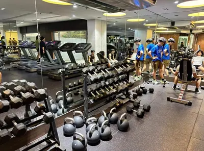 a group of people in a gym with weights at Spacious 1-BR Condo near BGC w Pool and Gym in Manila