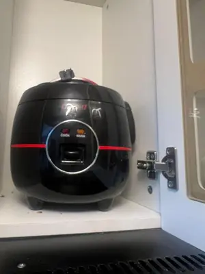 a black toaster sitting on a shelf in a kitchen at MCStaycation at Spring Residence Near Airport in Manila
