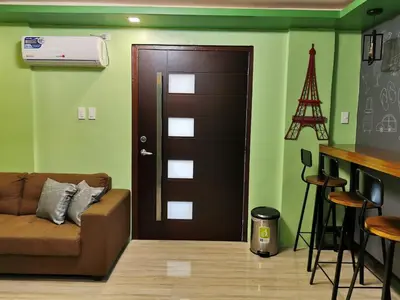 a living room with a brown door and a bar at Private Room Casa de los Reyes Kings' HouseHomestay in San Pedro