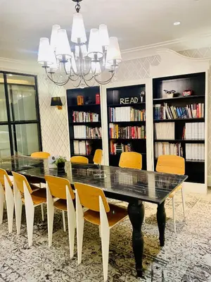 a dining room with a table and chairs and bookshelves at Designer Pad Town with Free Pool, Gym and Smart TV and Fast Wifi in Manila