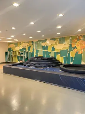a bed in a room with a mural on the wall at Venice McKinley Stay with Pool, Gym, fast Wifi and Netflix in Manila