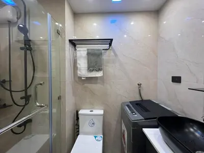 a small bathroom with a toilet and a shower at Harbor Calm Suite in Manila