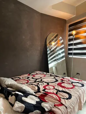 a bedroom with a bed with a bedspread with roses on it at A&K Staycations by Shell Residences MOA in Manila