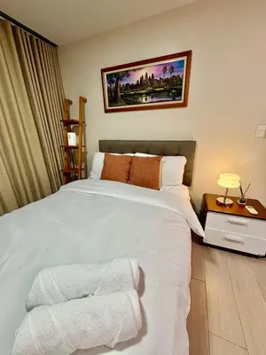 a bedroom with a large white bed with towels on it at Uptown Home 1BR at One Uptown Residence BGC in Manila